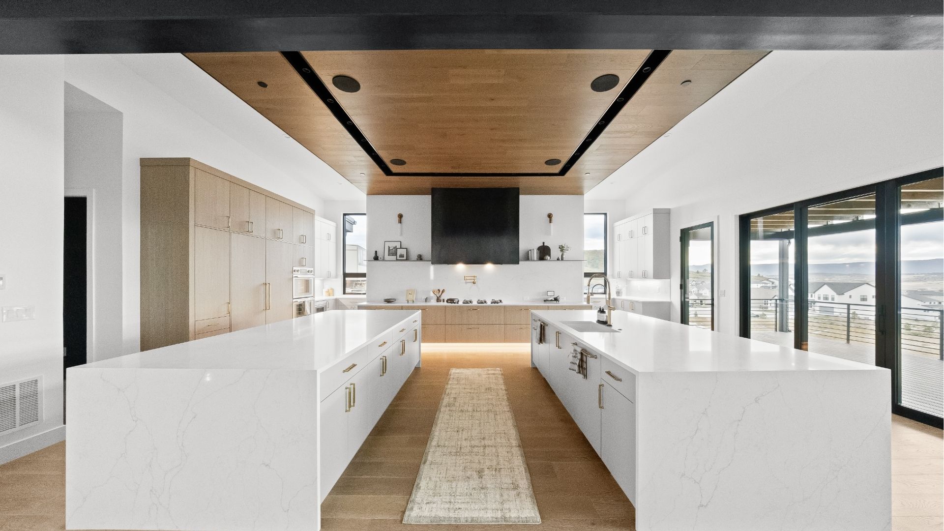 Gourmet kitchen with dual islands and wood ceiling detail in Castle Rock luxury ranch