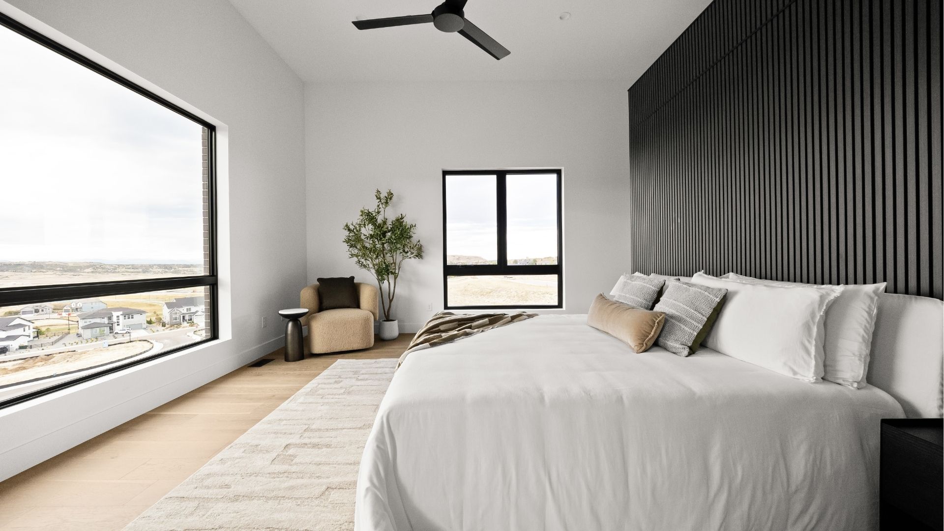 Primary bedroom with wood slat accent wall and panoramic views in Castle Rock luxury ranch