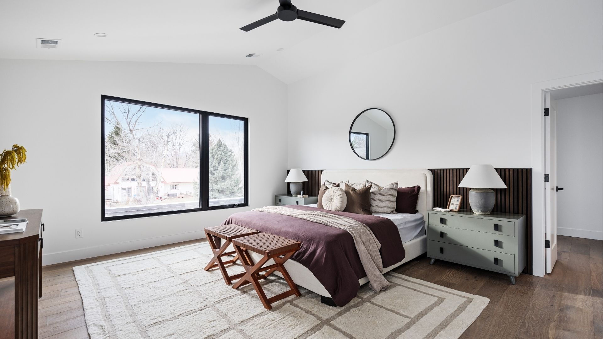 Spacious primary bedroom with black-framed windows in Applewood West Golden home