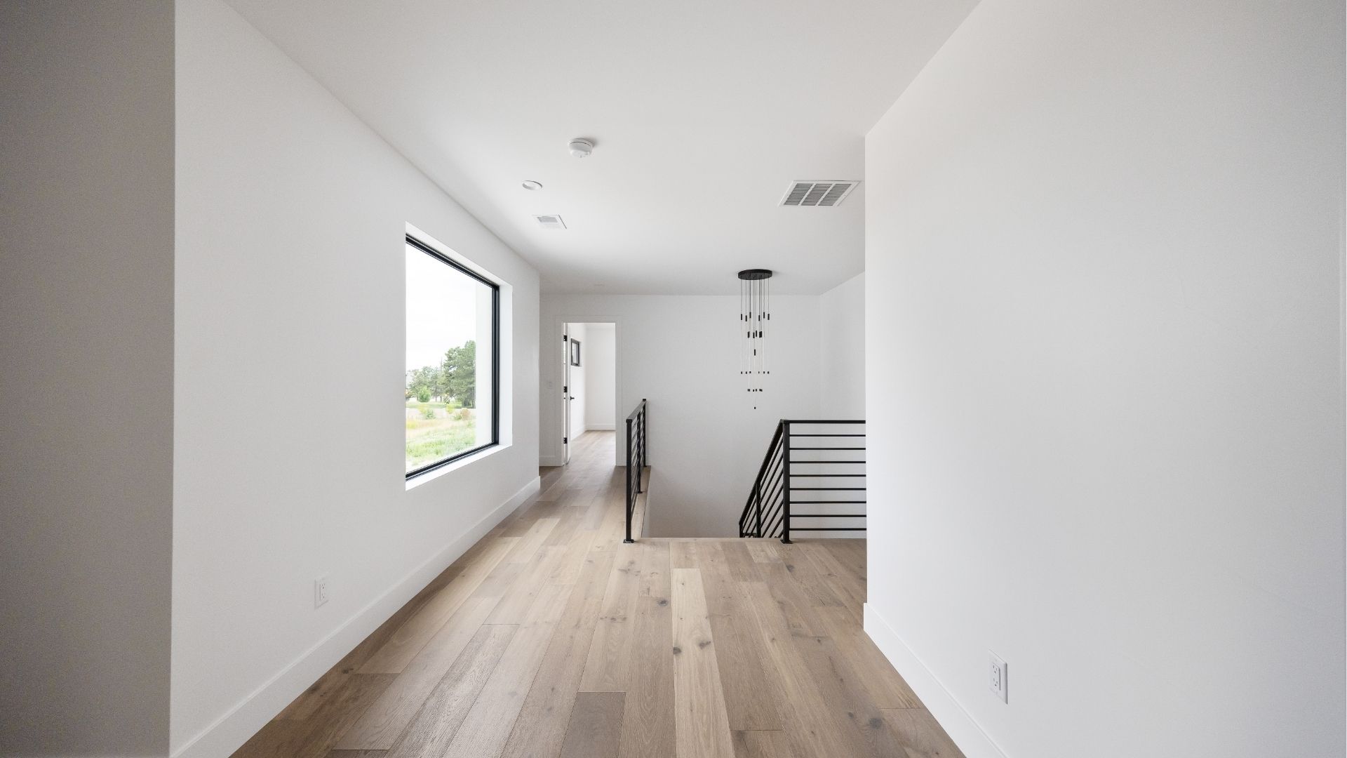 Upper level loft with custom steel railing and hardwood flooring in Golden luxury home