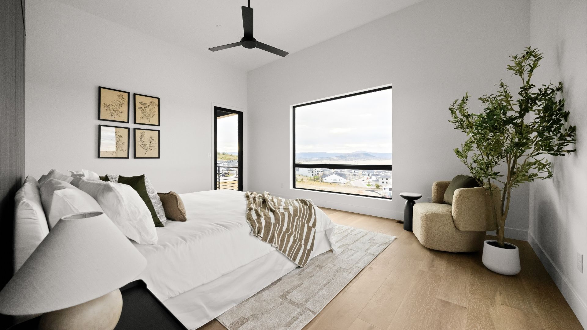 Primary bedroom with panoramic mountain and valley views in Castle Rock luxury ranch home