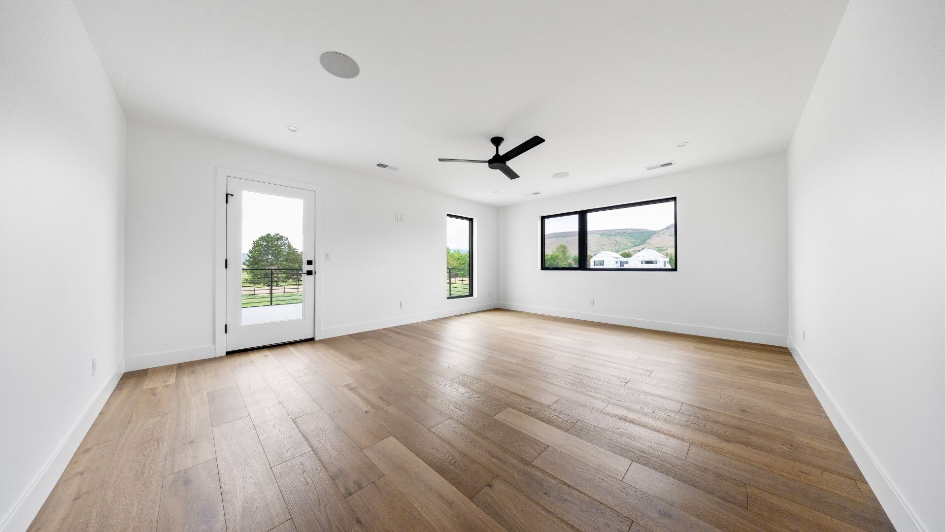 Primary bedroom with private deck access and mountain views in new construction Golden home