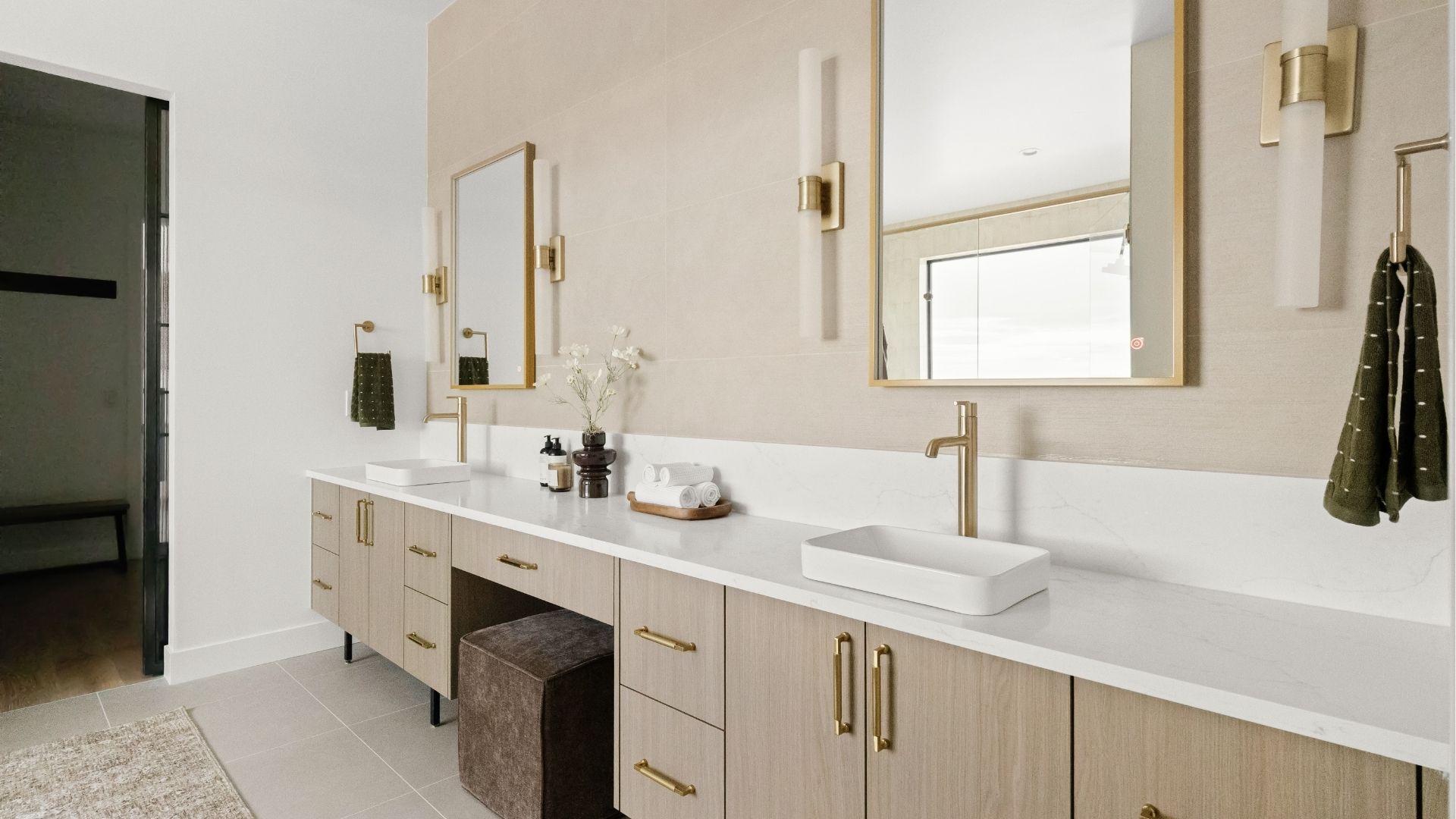 Primary bathroom vanity with built-in makeup area and gold accents in Castle Rock home