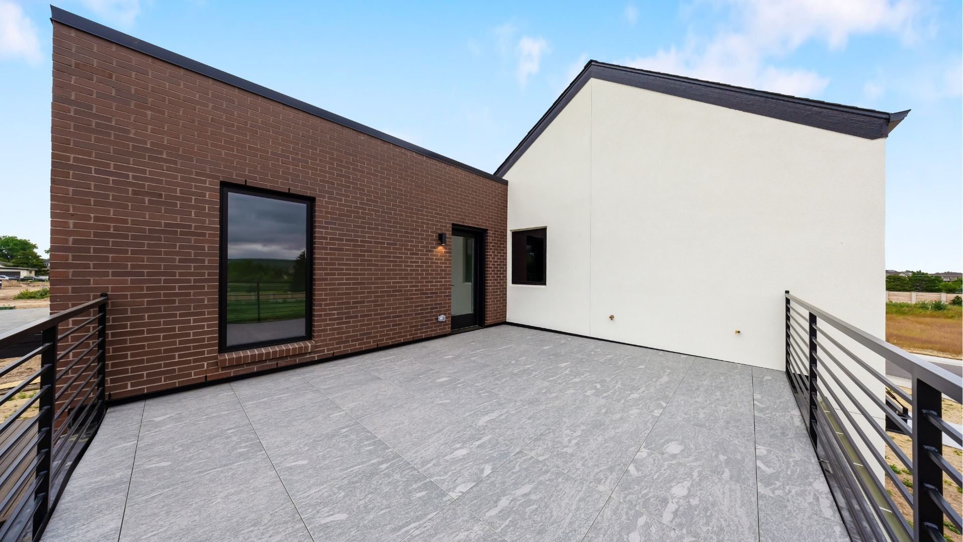 Private rooftop deck with custom steel railings and mixed material exterior in Golden home