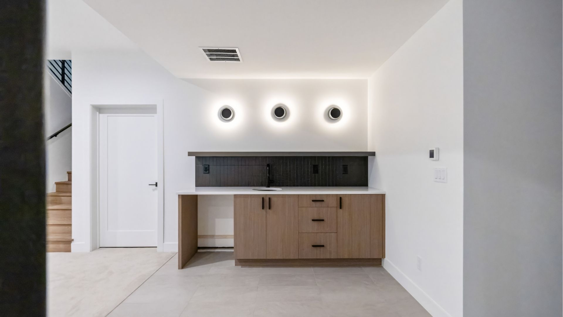 Basement wet bar with custom wood cabinetry and designer lighting in Golden luxury home