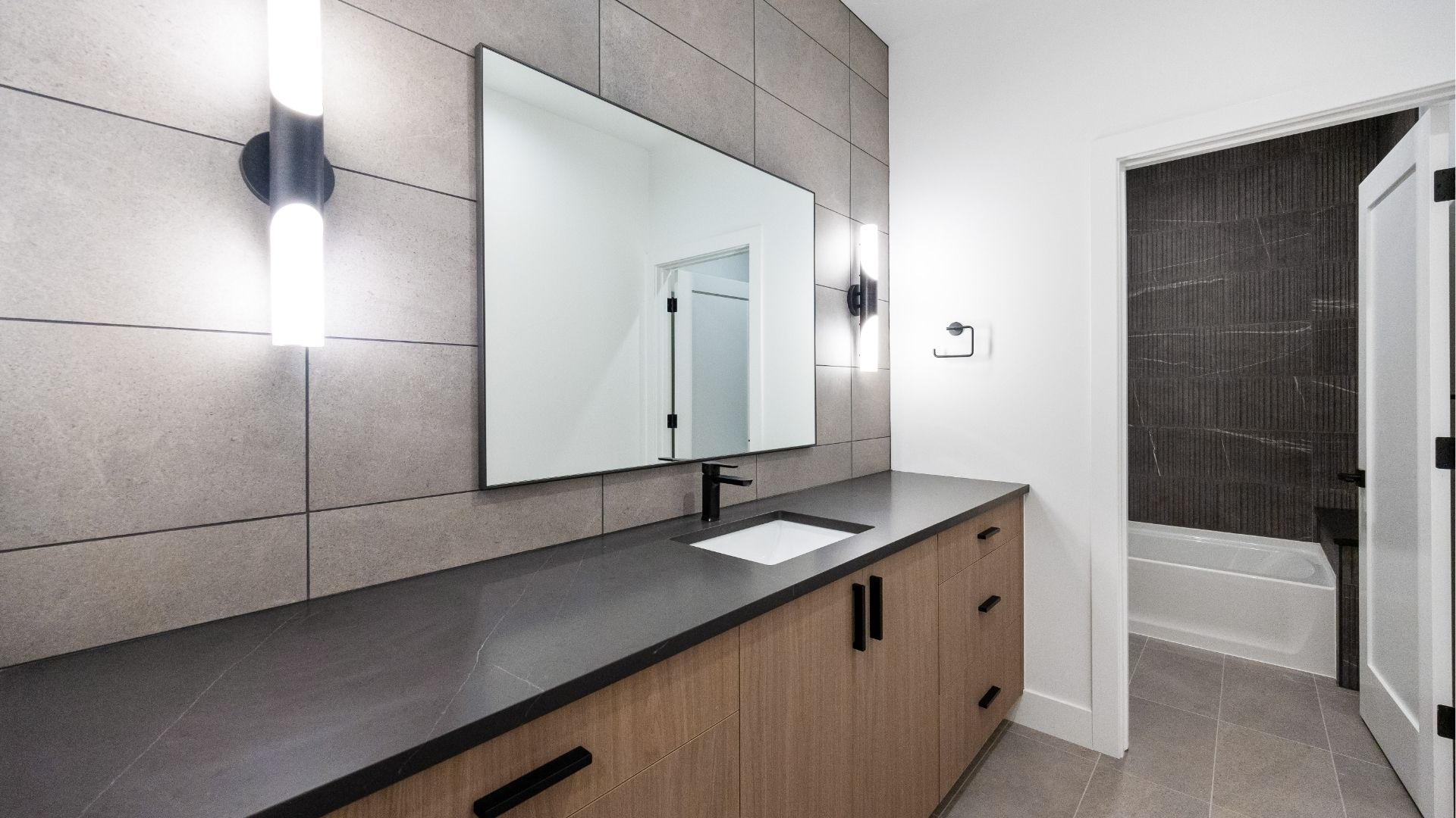 Contemporary basement bathroom with modern tile and wood vanity in new construction Golden home