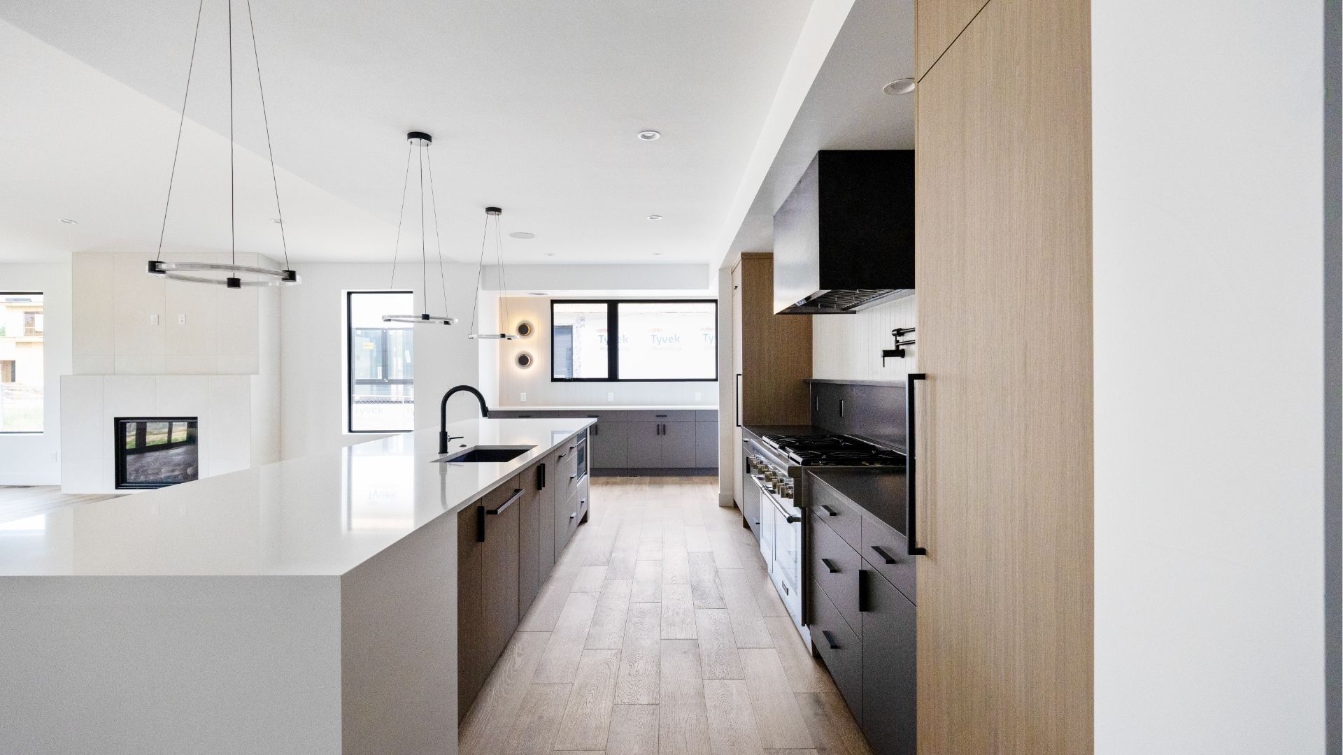 Modern kitchen with quartz waterfall island and two-tone cabinetry in new construction Golden home