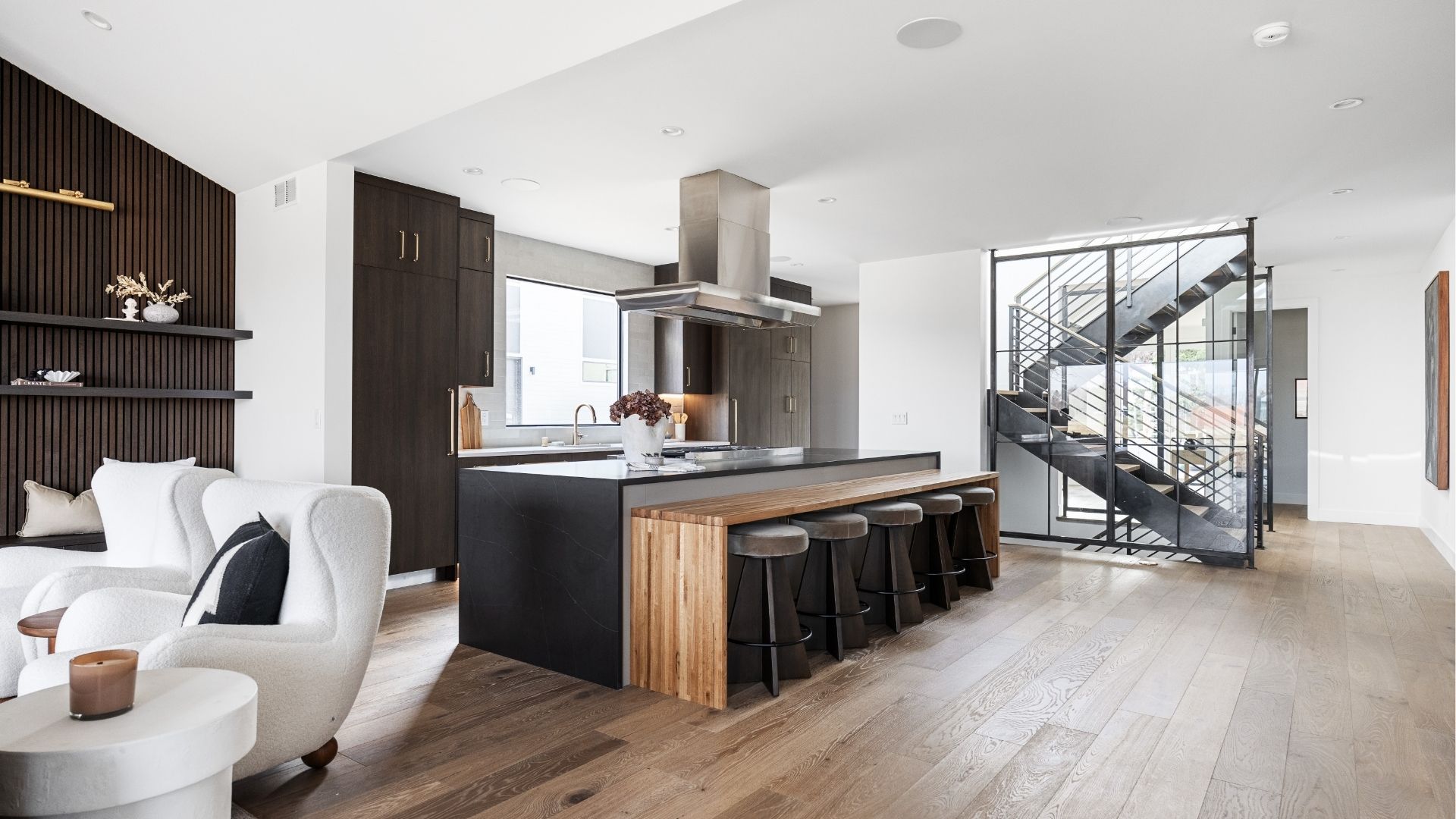 Modern kitchen with custom steel staircase and wood flooring in luxury Golden home