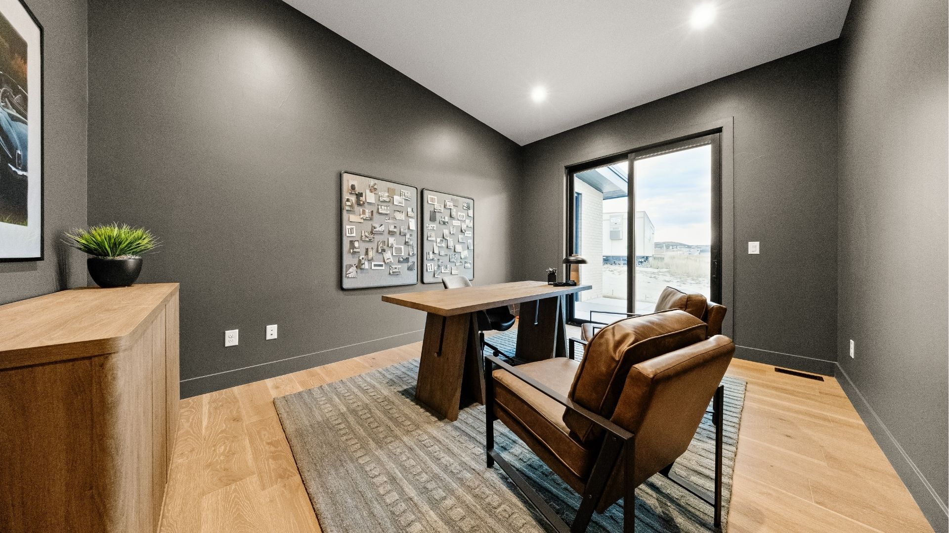 Home office with wood desk and dark accent walls in Castle Rock modern ranch