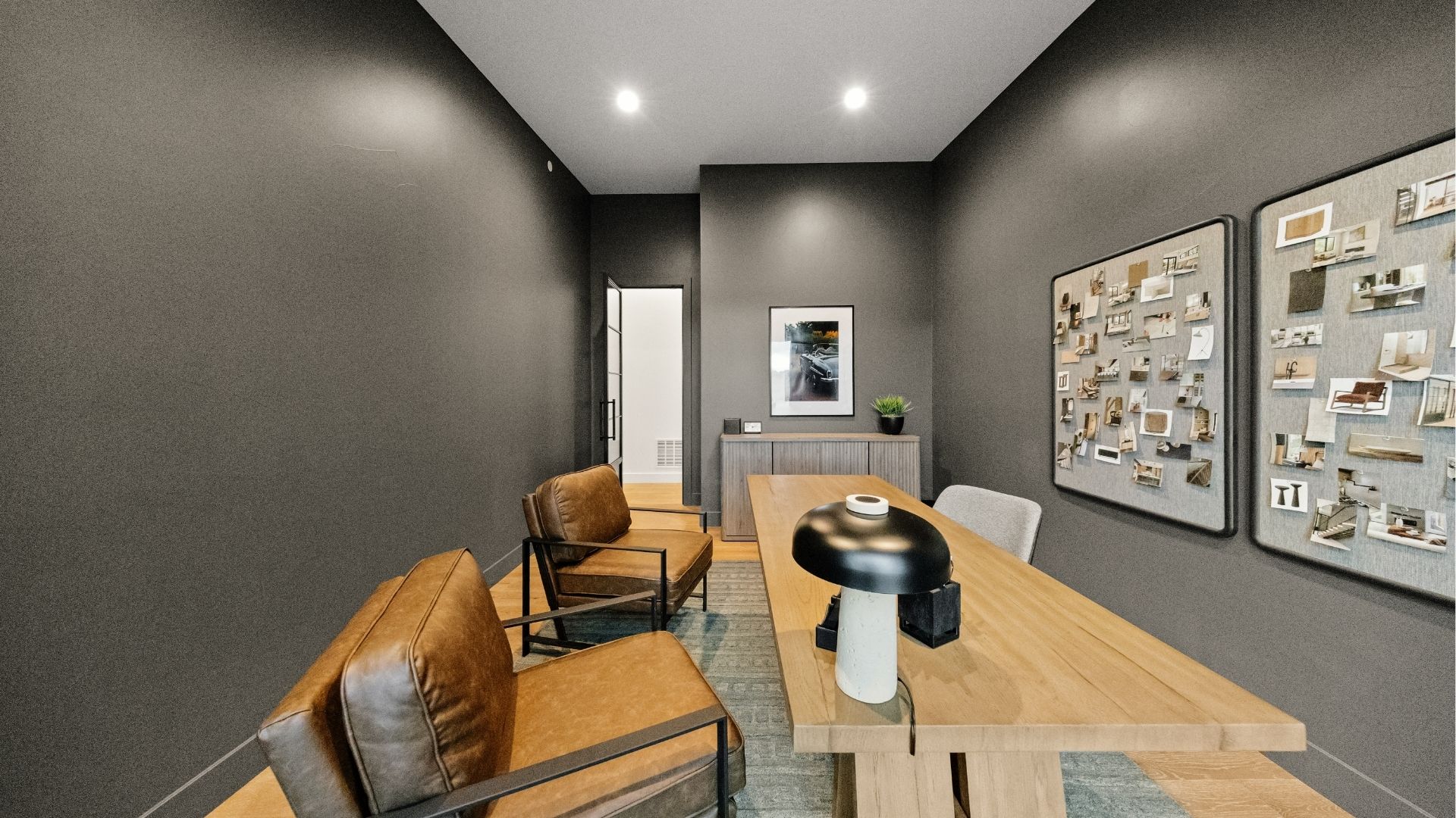 Home office with dark accent walls and custom wood desk in Castle Rock luxury ranch