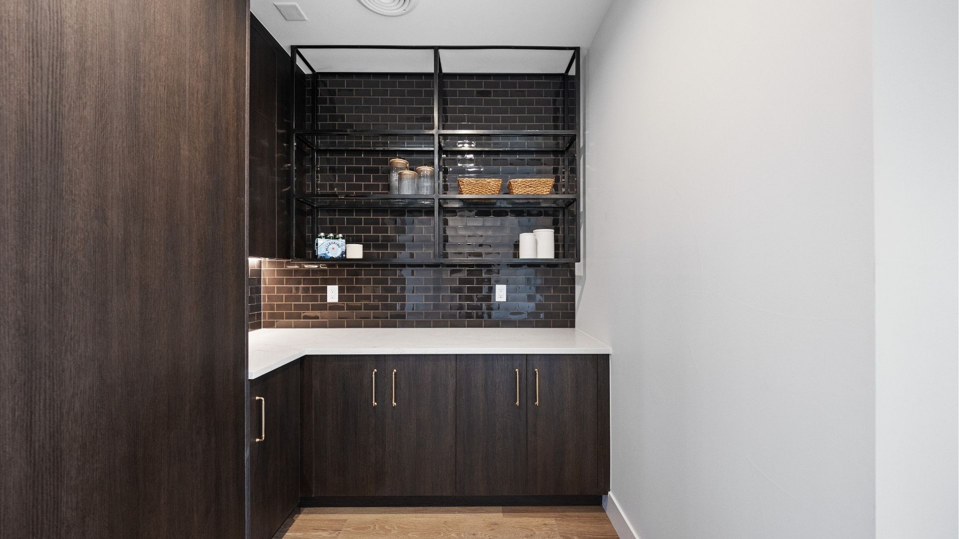Custom pantry with steel shelving and dark cabinetry in Applewood West luxury home