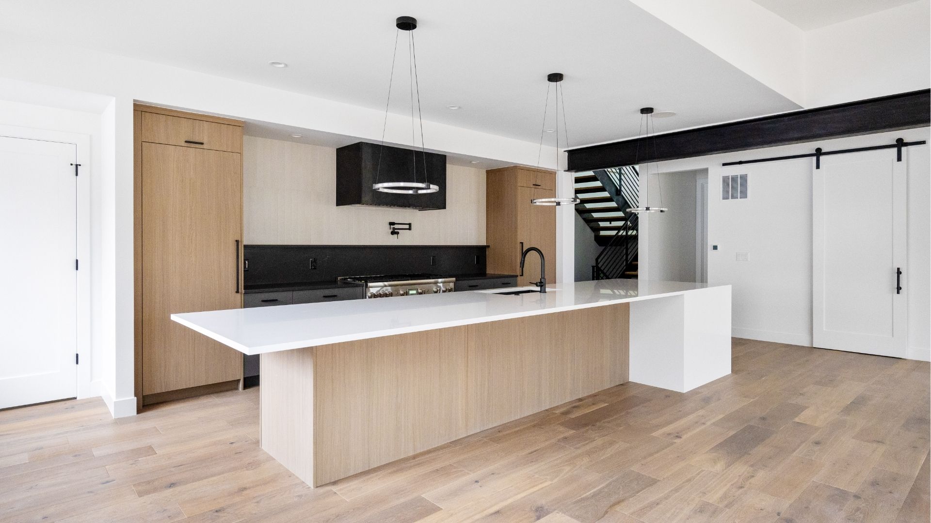 Eat-in kitchen with large island and custom barn door in move-in ready Golden luxury home