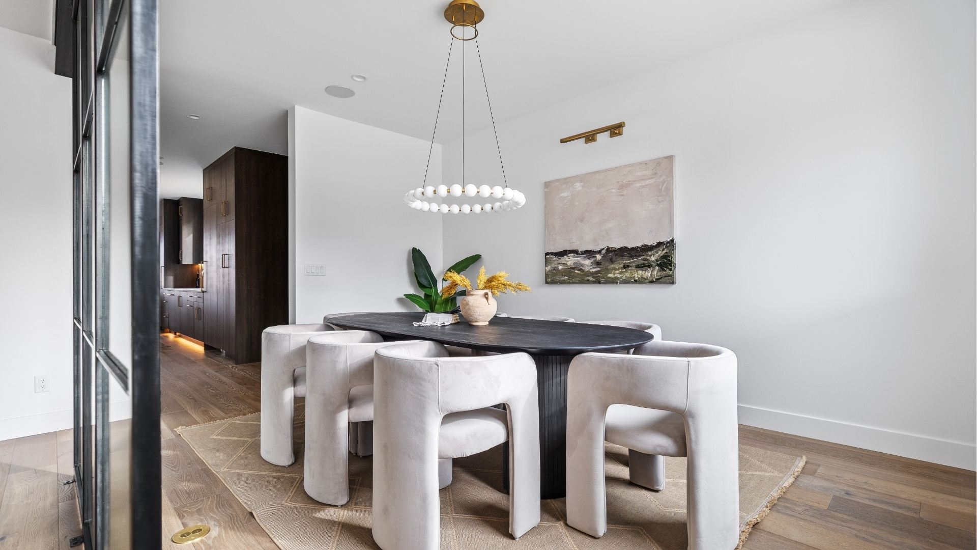Modern dining room with designer lighting and wood flooring in Applewood West Golden home