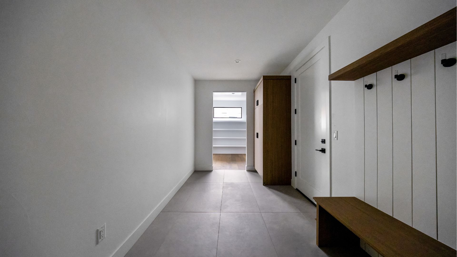 Modern mudroom with custom wood bench and built-in storage in new construction Golden home