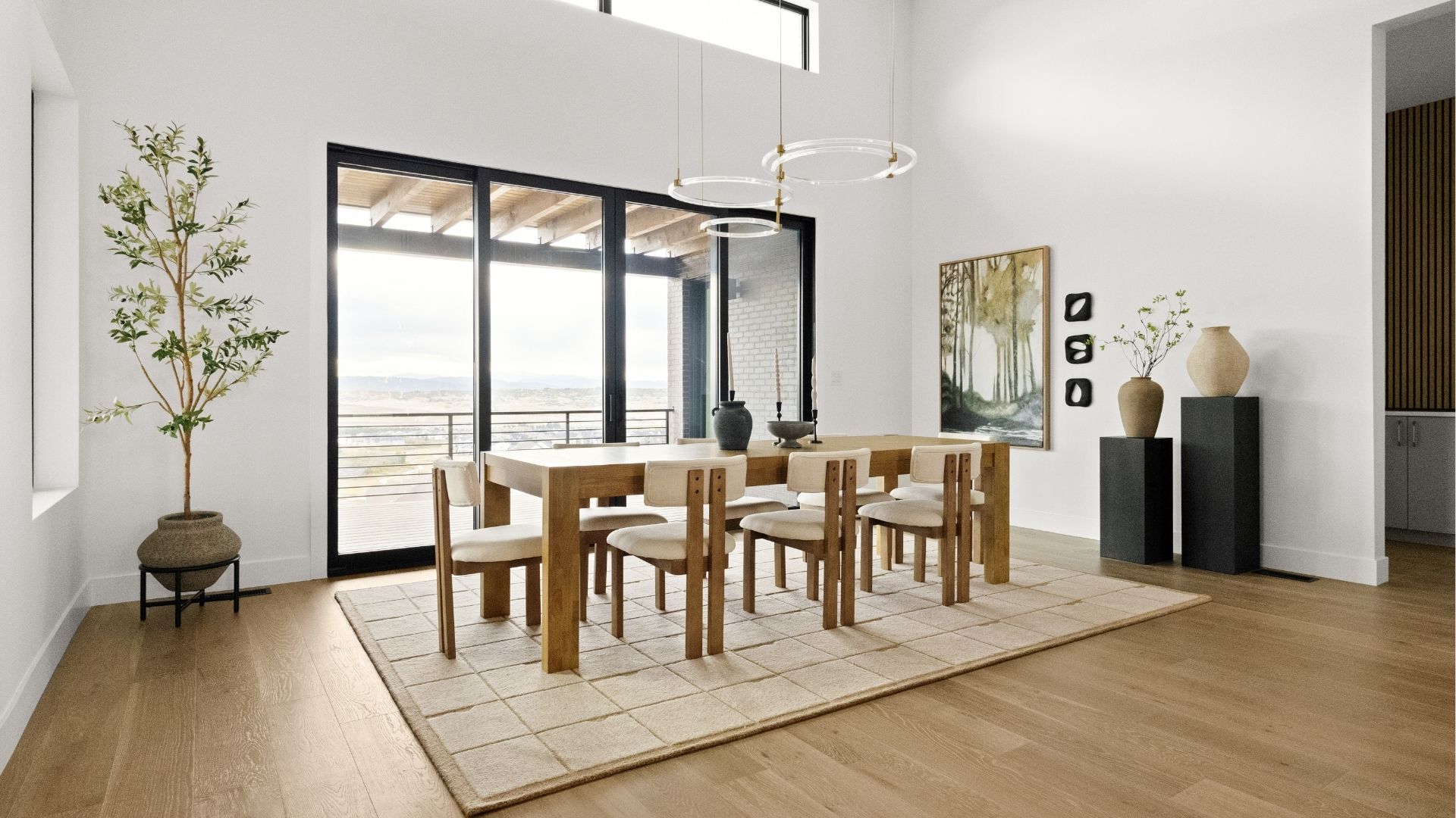 Modern dining room with mountain backdrop and custom wood accent wall in Castle Rock home
