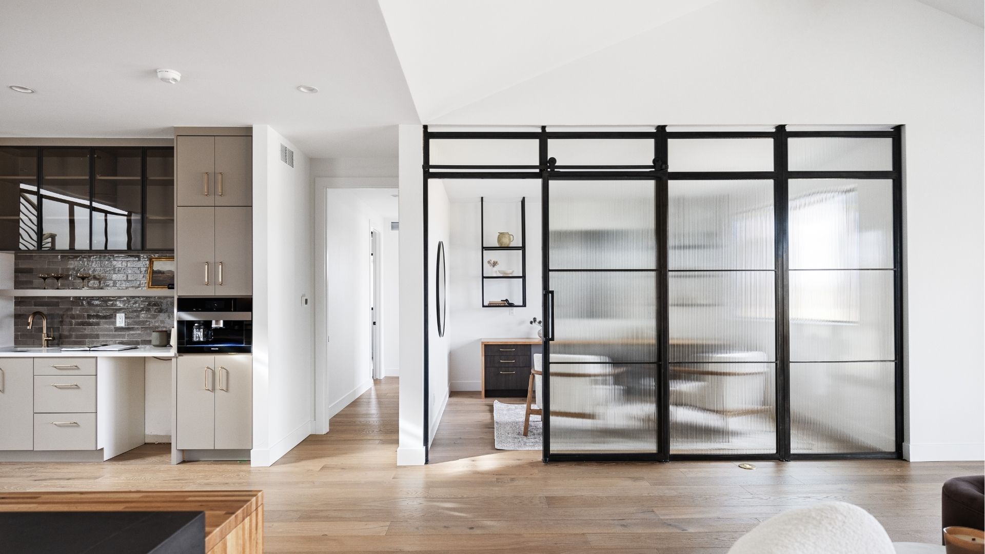Custom steel and reeded glass office partition in open-concept Applewood West home