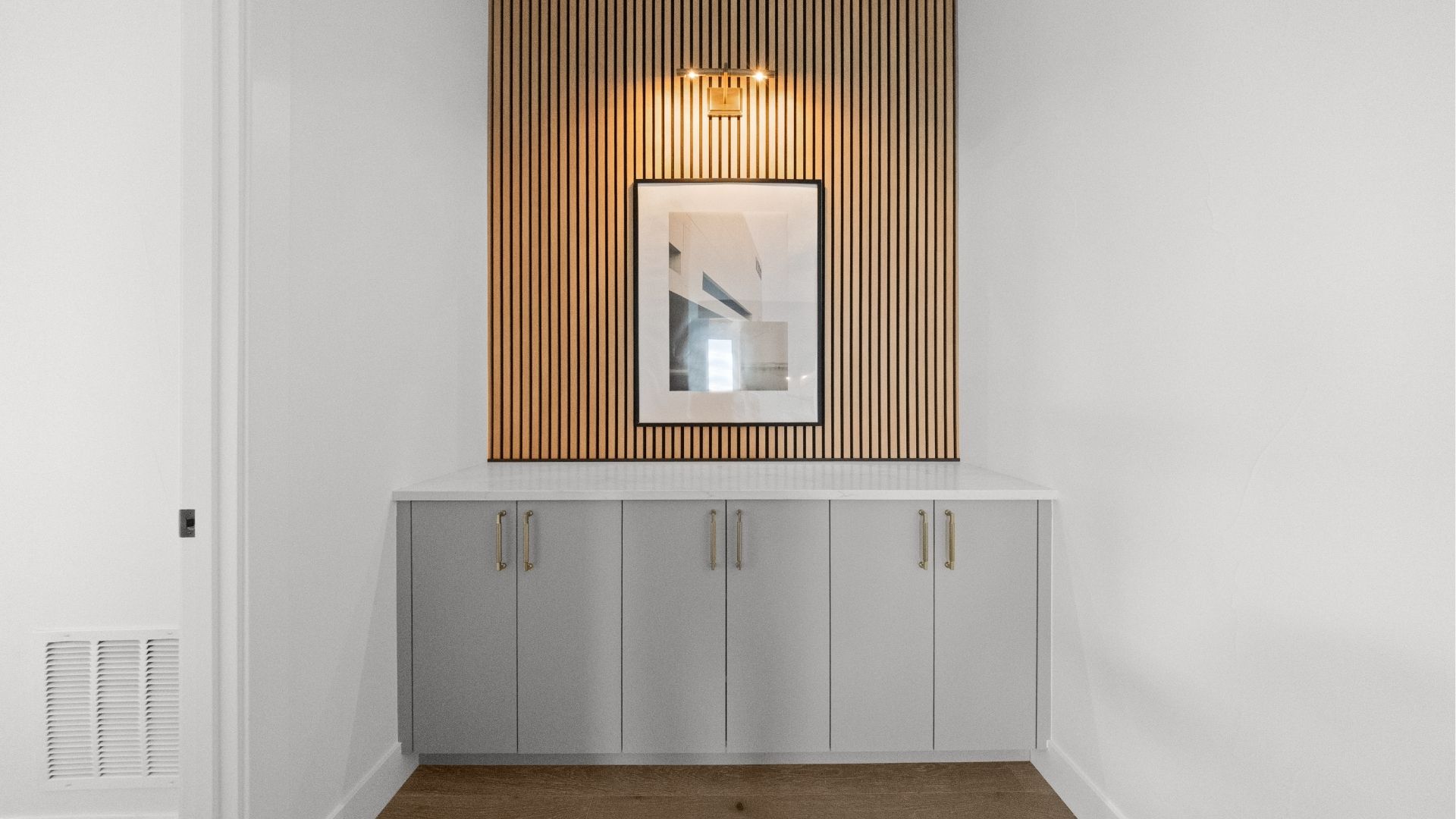 Custom storage built-in with wood slat accent wall at Castle Rock primary suite entry