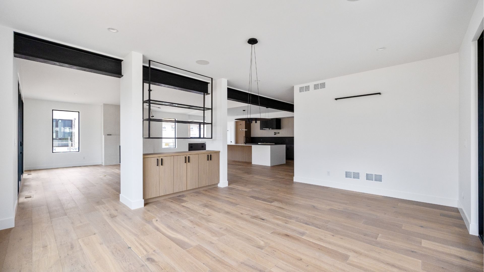 Open-concept dining area with custom steel shelving and wood accents in new construction Golden home