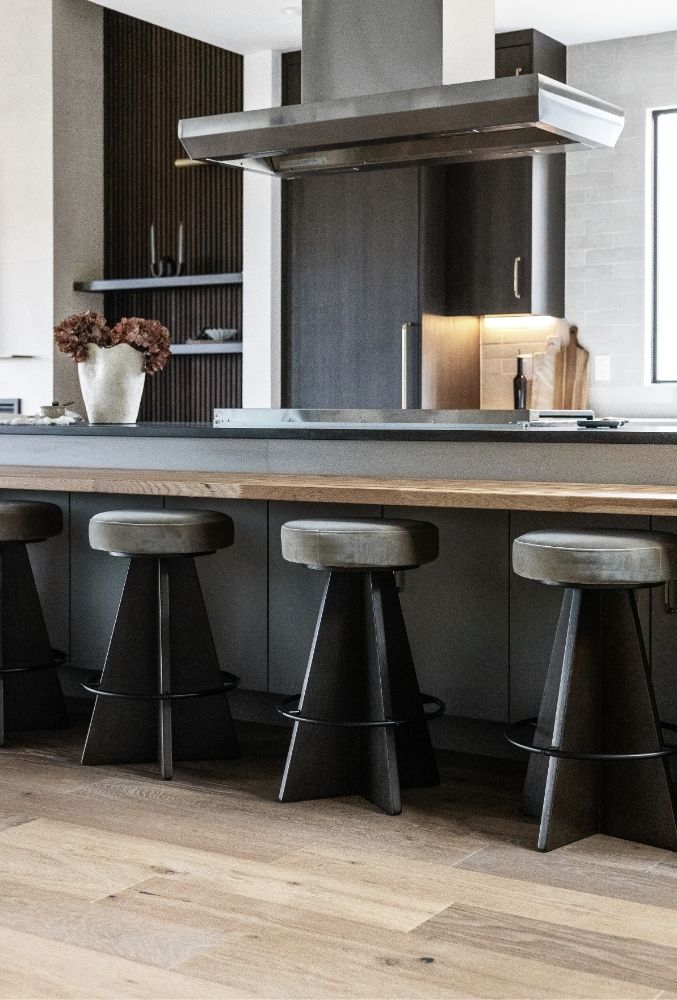 Modern kitchen island with dark cabinetry and quartz countertops in Applewood West luxury home