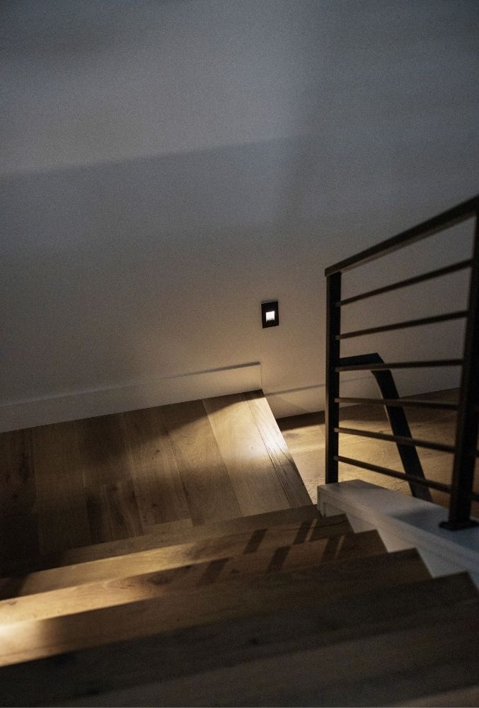 Custom staircase with steel handrail and integrated lighting in modern Golden luxury home by Work Shop Colorado