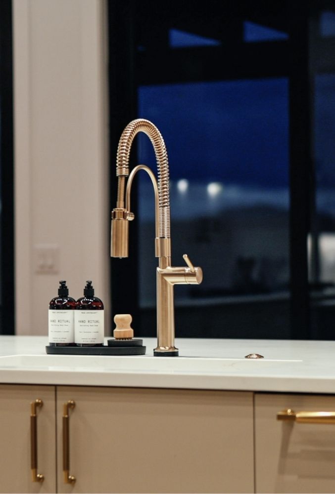 Gold kitchen faucet with mountain views in Castle Rock Signature at Crystal Valley home