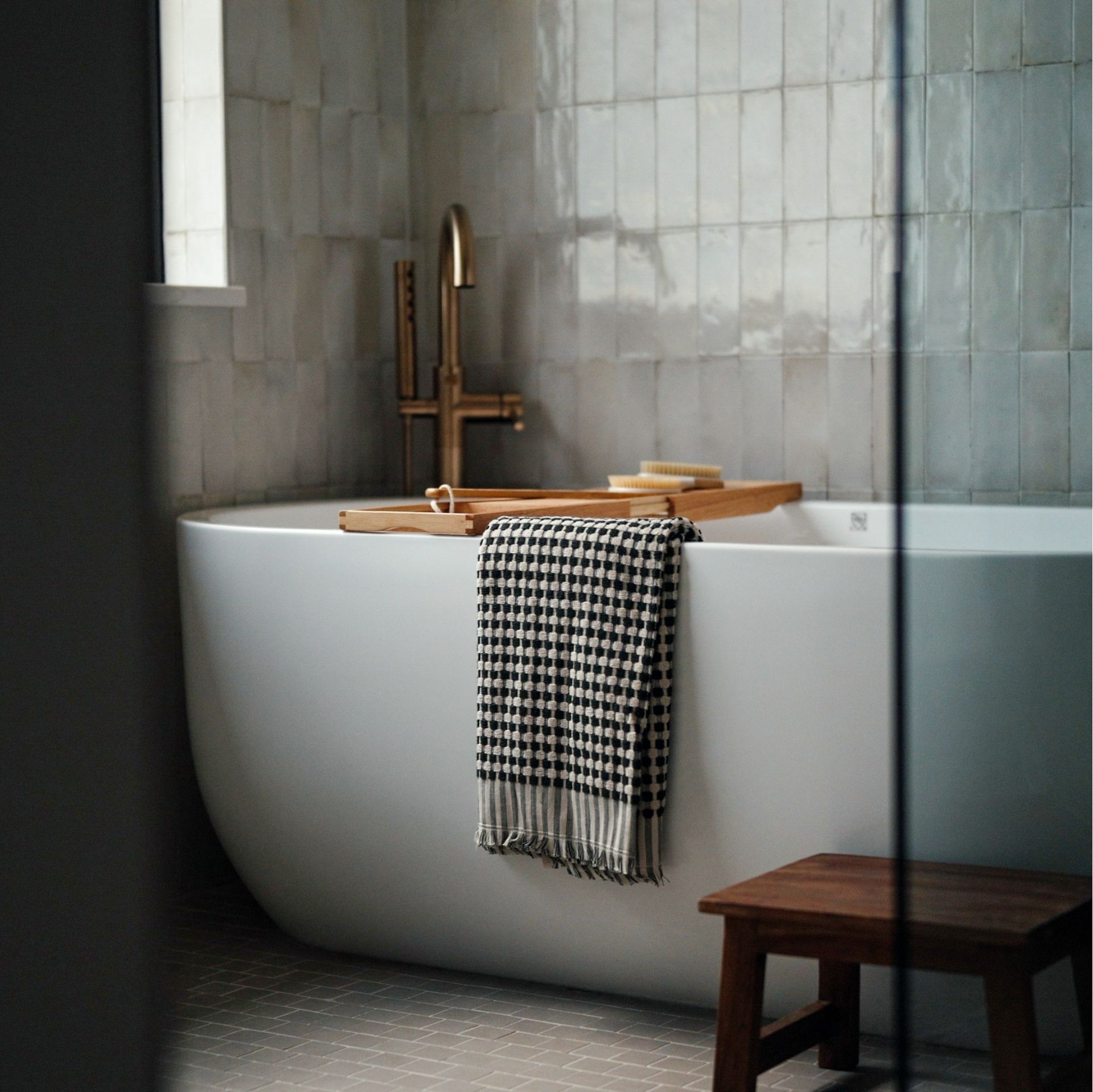 Freestanding soaking tub with gold fixtures in Castle Rock luxury ranch bathroom