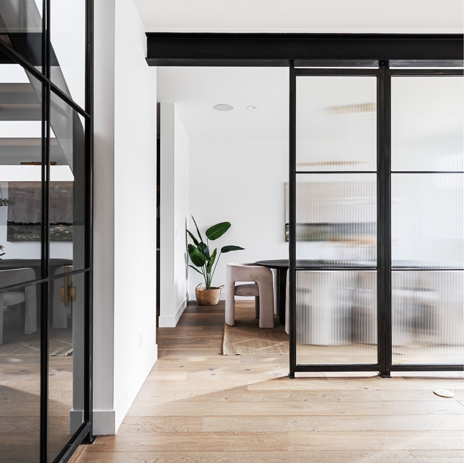 Custom steel and glass partition separating dining area in modern Golden Colorado home