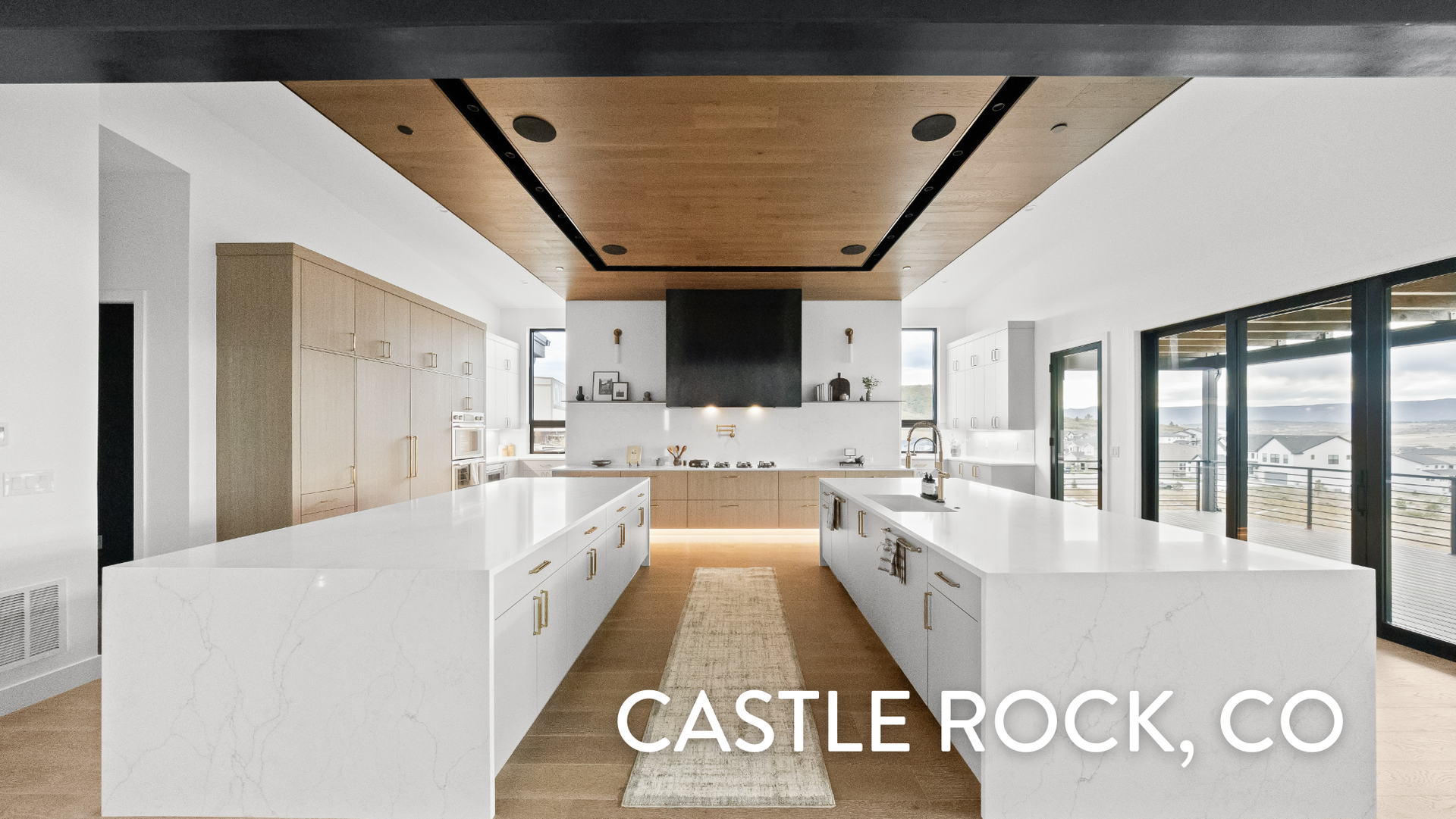 Gourmet kitchen with dual islands and wood ceiling detail in Castle Rock luxury ranch