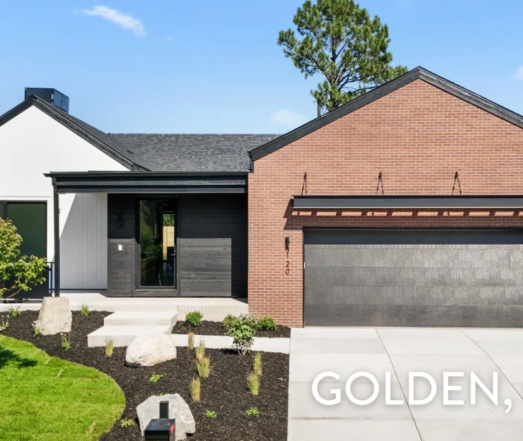Luxury ranch home with red brick exterior, black trim, and custom wood entry detail in Applewood, Golden, CO — built by Work Shop Colorado