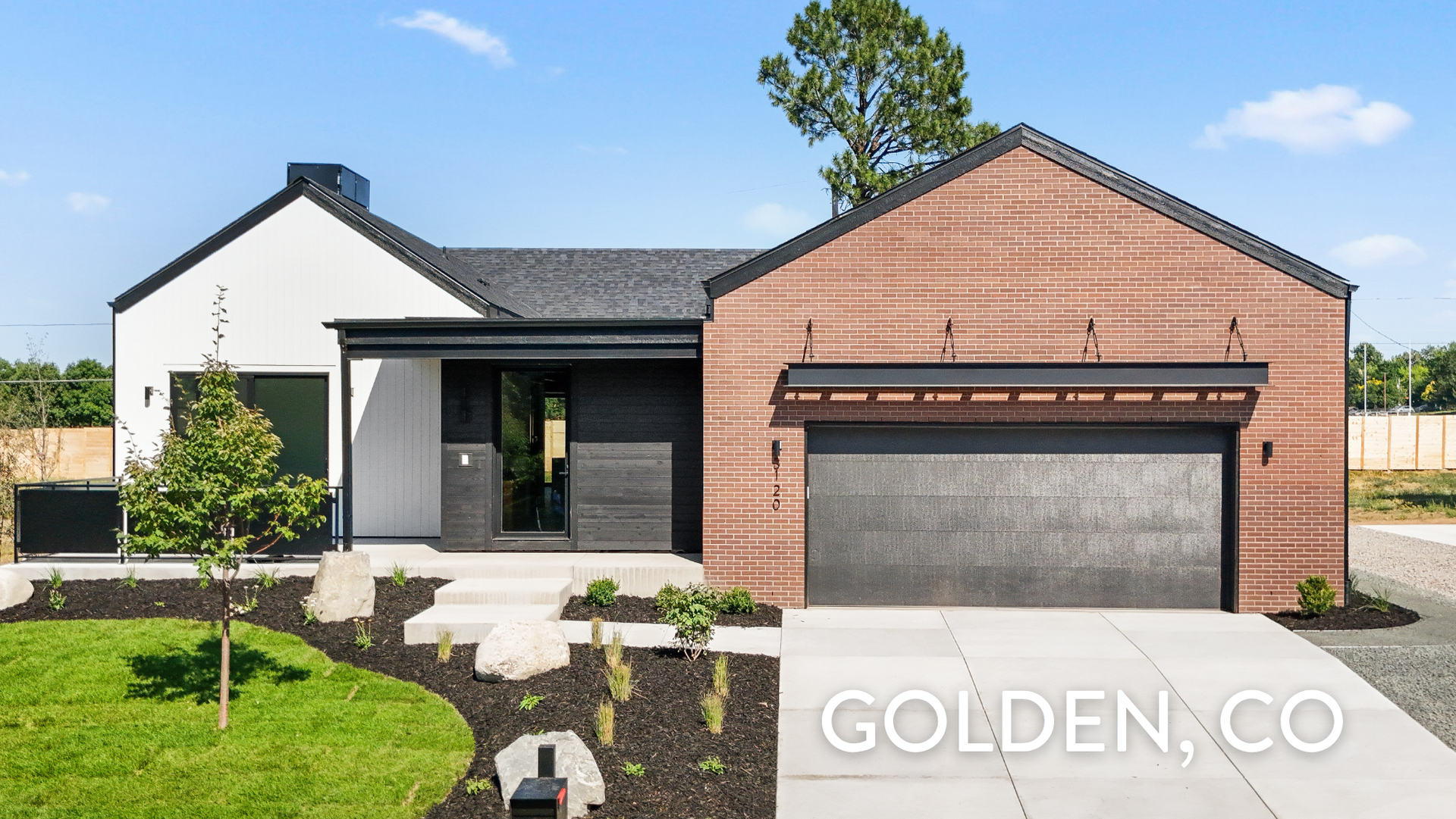 Luxury ranch home with red brick exterior, black trim, and custom wood entry detail in Applewood, Golden, CO — built by Work Shop Colorado