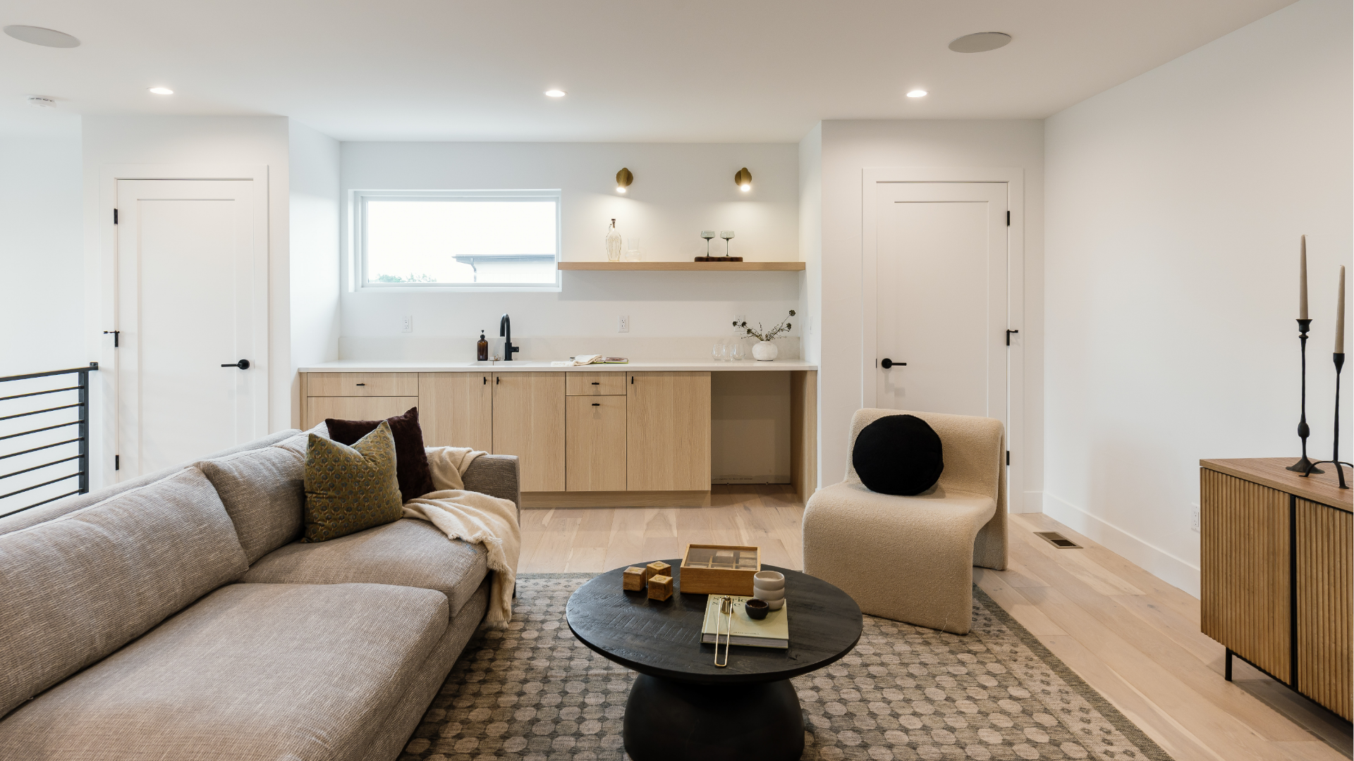 Sitting area facing a built-in wet bar with brass sconces in a third-floor loft