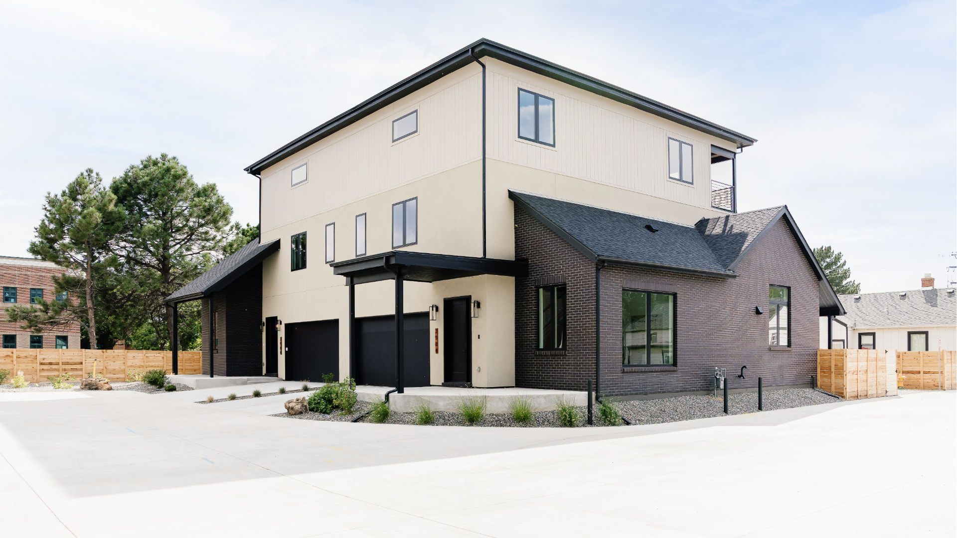 Exterior view of a modern duplex with dark brick accents and covered entries for sale