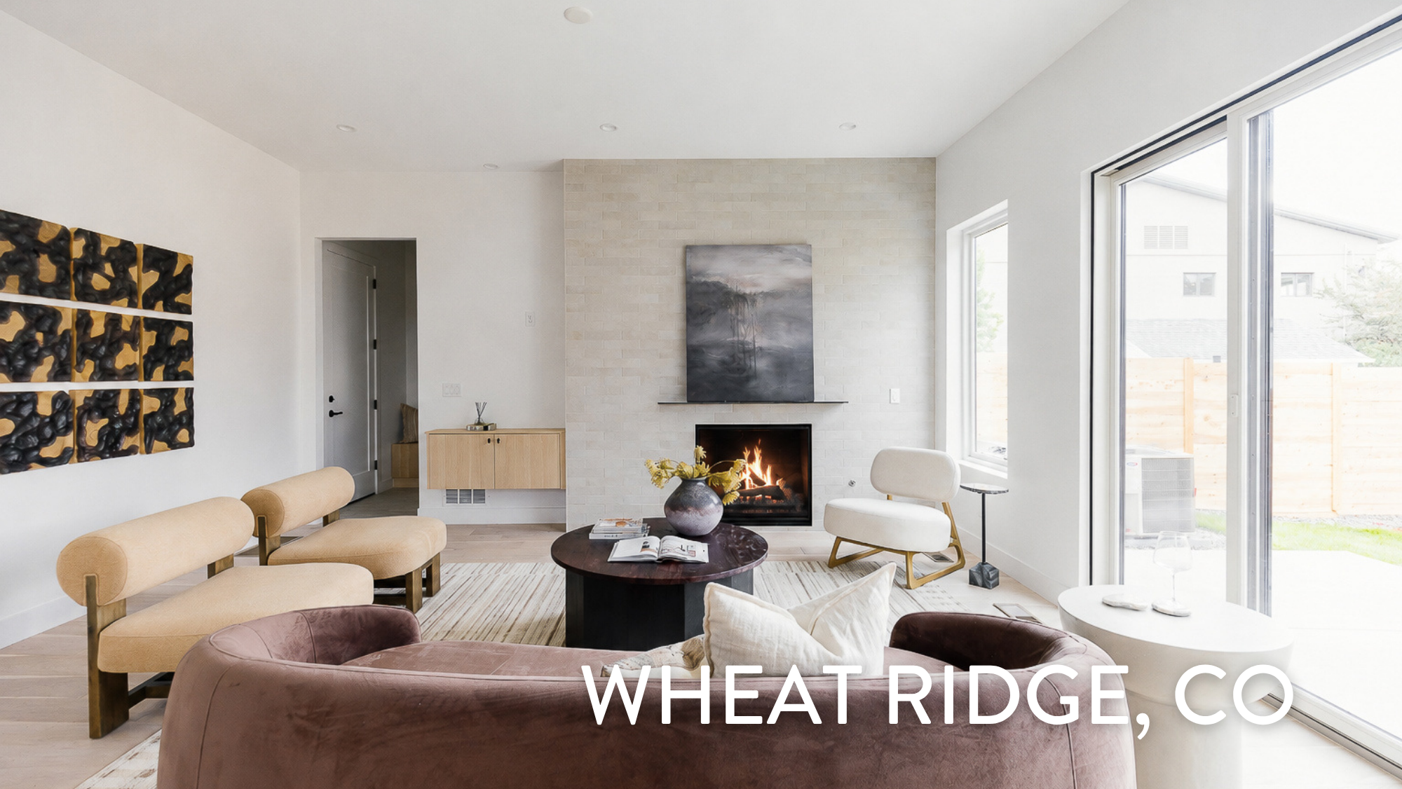 Modern living room with tile fireplace surround and large sliding glass doors in a luxury duplex at 3904 Upham St, Wheat Ridge, CO